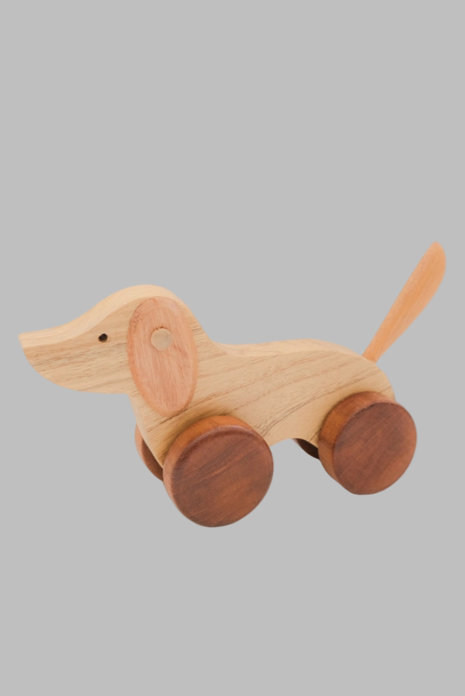 Wooden toy dog with wheels on a light background